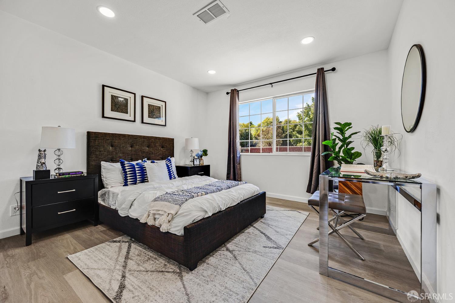3138 Flannery Road San Pablo, CA 94806 - Photo 19 of 38 a bedroom with a bed a table and a potted plant