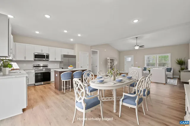 a large kitchen with stainless steel appliances granite countertop a large counter top a stove and a wooden floors