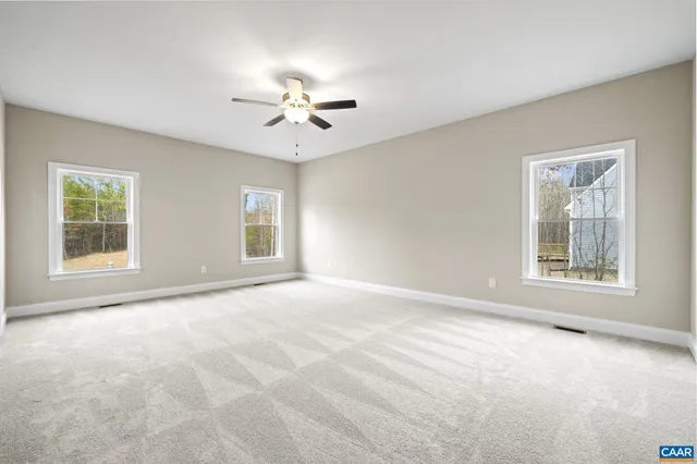 a view of an empty room with a chandelier fan