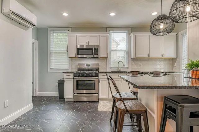 a kitchen with stainless steel appliances a stove a sink and a microwave