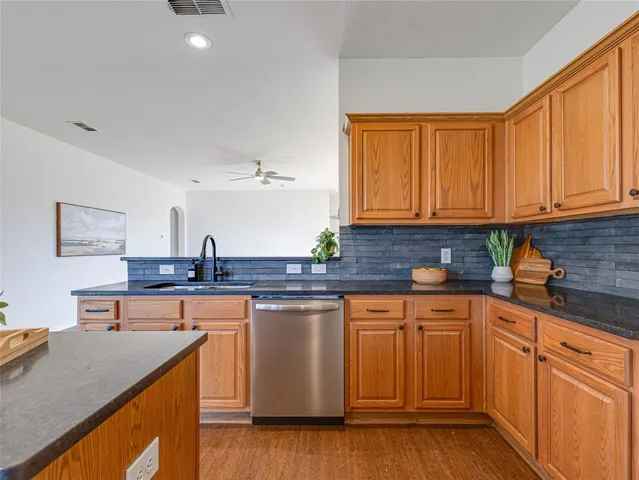 a kitchen with stainless steel appliances granite countertop a sink stove and cabinets