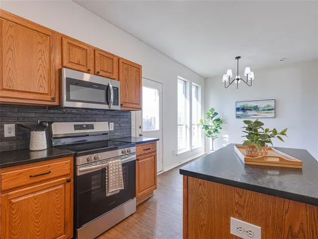 a kitchen with stainless steel appliances granite countertop a stove microwave and cabinets