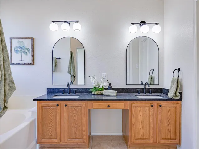 a bathroom with double vanity sinks and a mirror