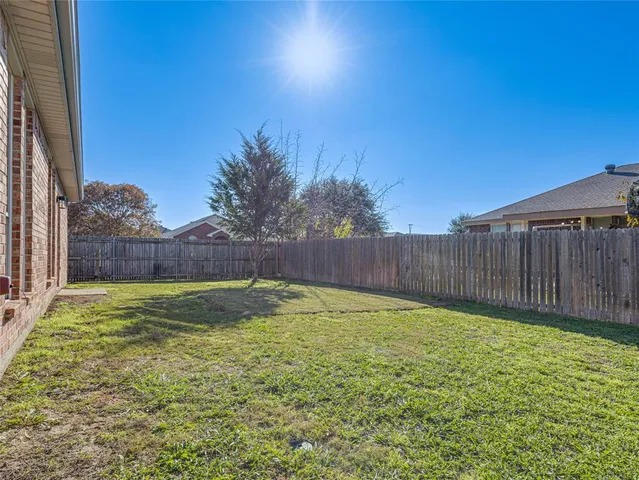 a view of backyard with wooden fence