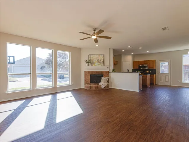 a view of a livingroom with wooden floor and a ceiling fan