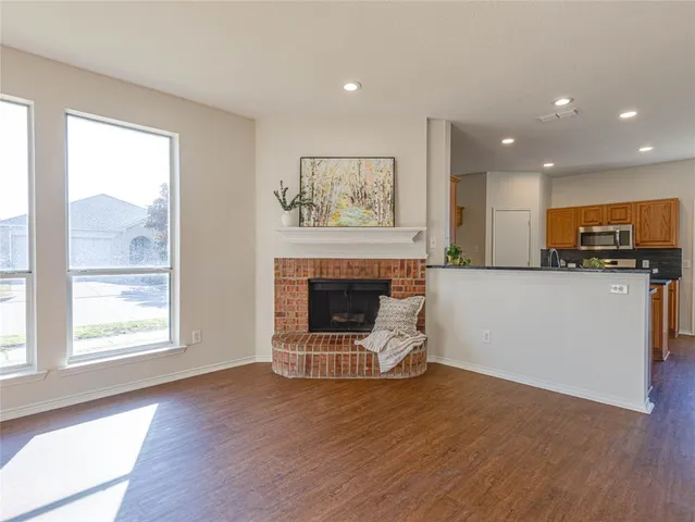 a view of a kitchen with furniture a fireplace and wooden floor