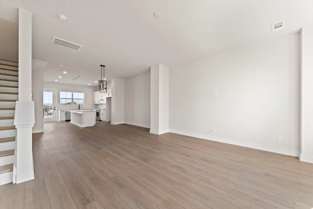 a view of a big room with wooden floor and a large window