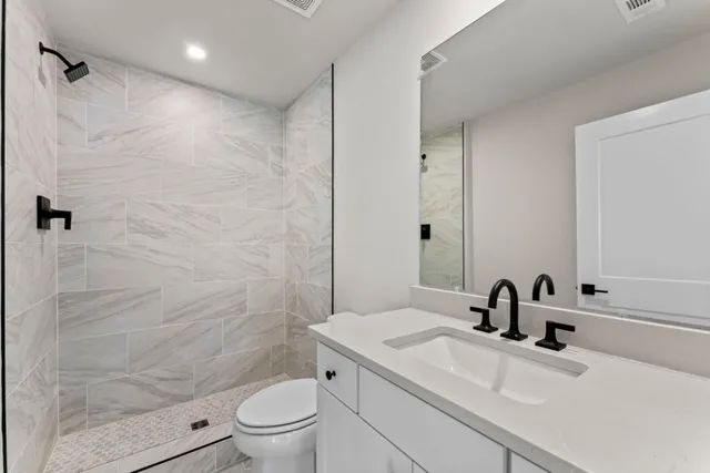 a bathroom with a sink a toilet and a mirror