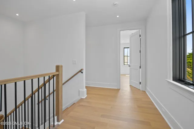 a view of a hallway with wooden floor and stairs