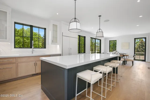 a kitchen with a dining table chairs sink and wooden floor