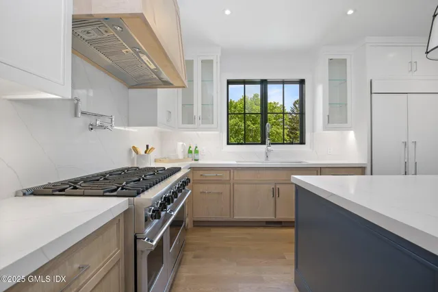 a kitchen with stainless steel appliances granite countertop a sink stove and cabinets
