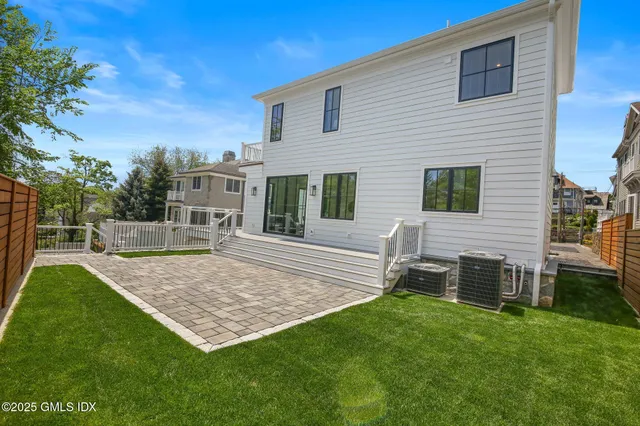 a view of a backyard with table and chairs potted plants and wooden fence