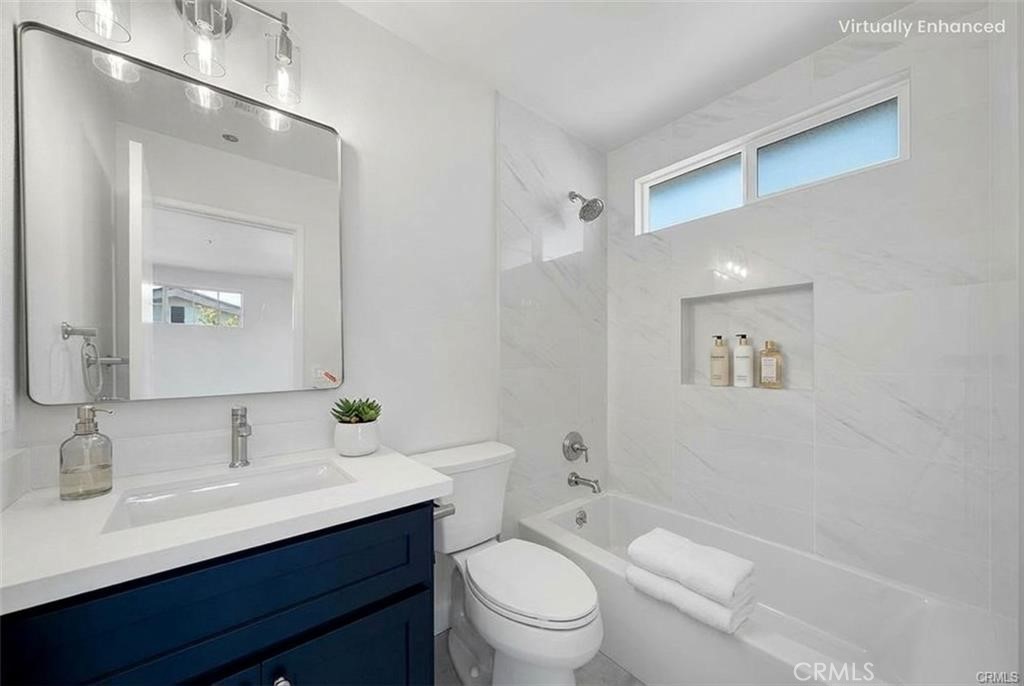 134 North Atlantic Boulevard, Unit B Alhambra, CA 91801 - Photo 12 of 18 a bathroom with a toilet a sink a mirror and vanity