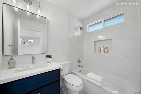 a bathroom with a toilet a sink a mirror and vanity