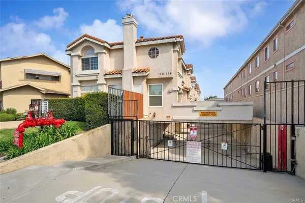 a view of a white house with wooden fence and potted plants