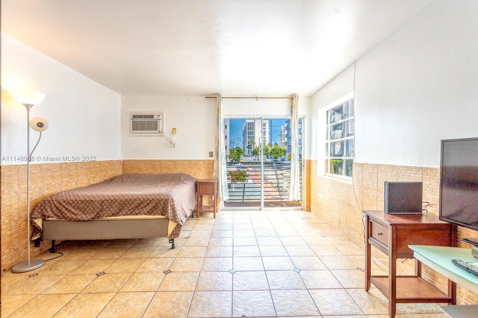 a spacious bedroom with a bed and a flat screen tv