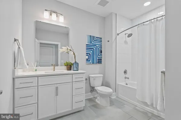 a bathroom with a toilet a sink and a large mirror