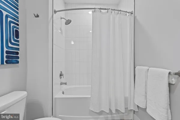 a bathroom with a shower curtain and a toilet