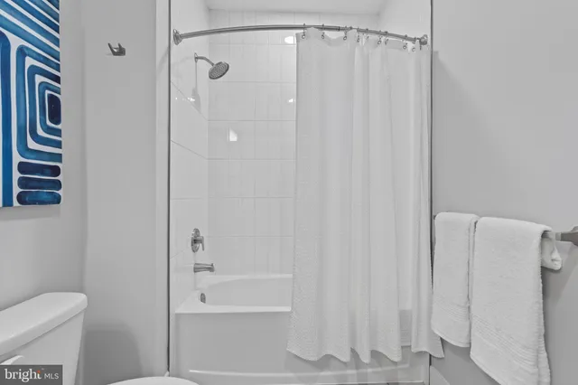 a bathroom with a shower curtain and a toilet