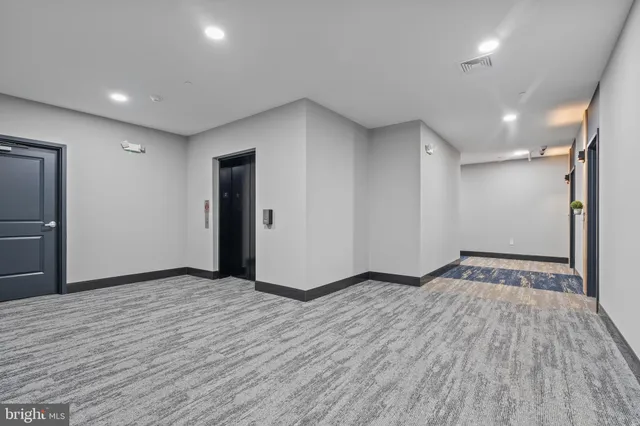 a view of an empty room with wooden floor and closet