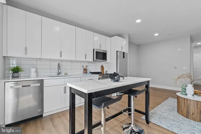 a kitchen with a sink cabinets and wooden floor