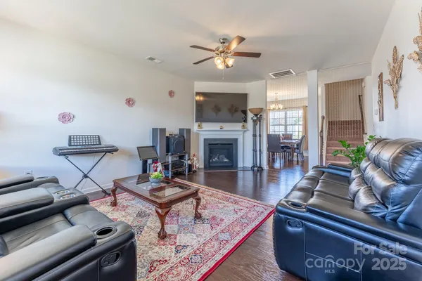 a living room with furniture a fireplace and flat screen tv