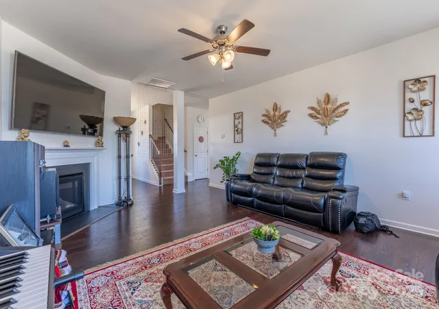 a kitchen with stainless steel appliances granite countertop a refrigerator a sink dishwasher a stove and a dining table with wooden floor