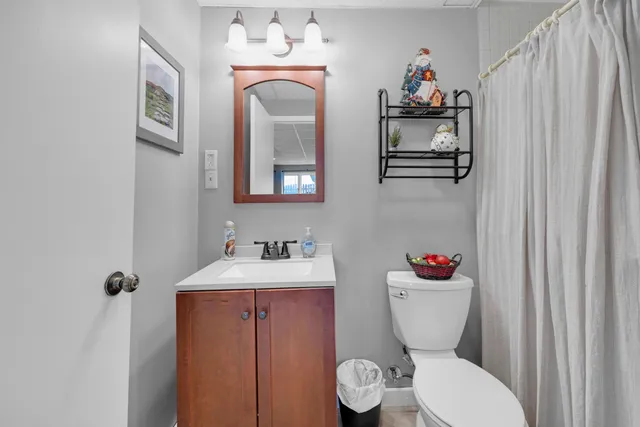 a bathroom with a toilet sink and mirror