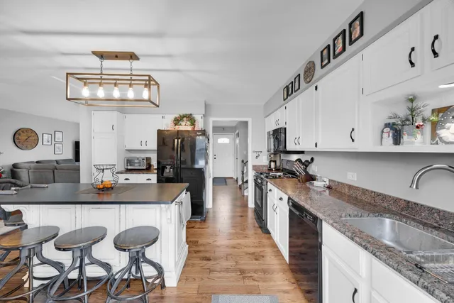 a kitchen with granite countertop a sink stove and cabinets