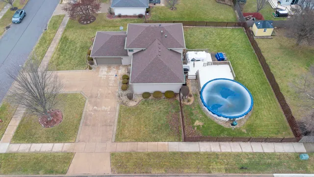 an aerial view of a house with garden space and a car parked