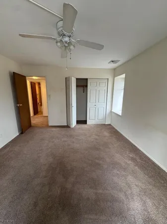 a view of a big room with windows and chandelier fan