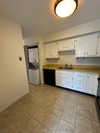 a kitchen with stainless steel appliances a sink a stove a refrigerator a window