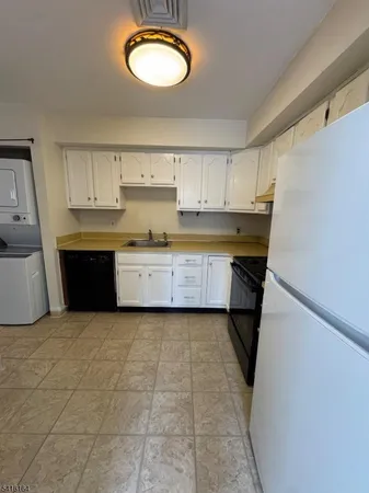 a large kitchen with a stove a sink dishwasher and a refrigerator