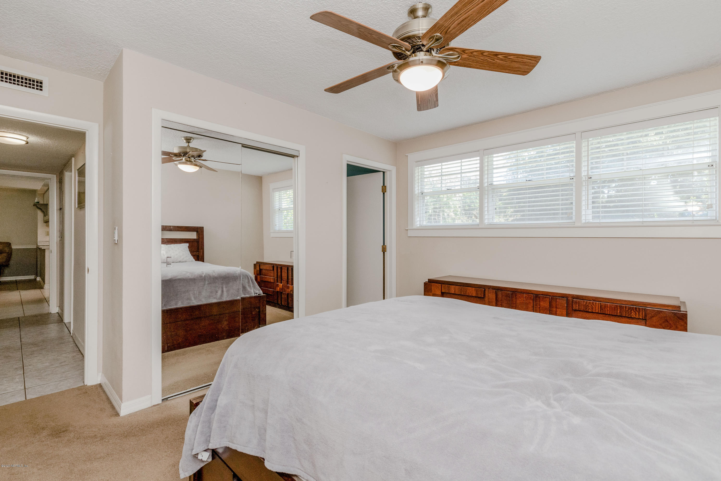 3118 Kline Road Jacksonville, FL 32246 - Photo 19 of 39 a bedroom with a large bed and a chandelier