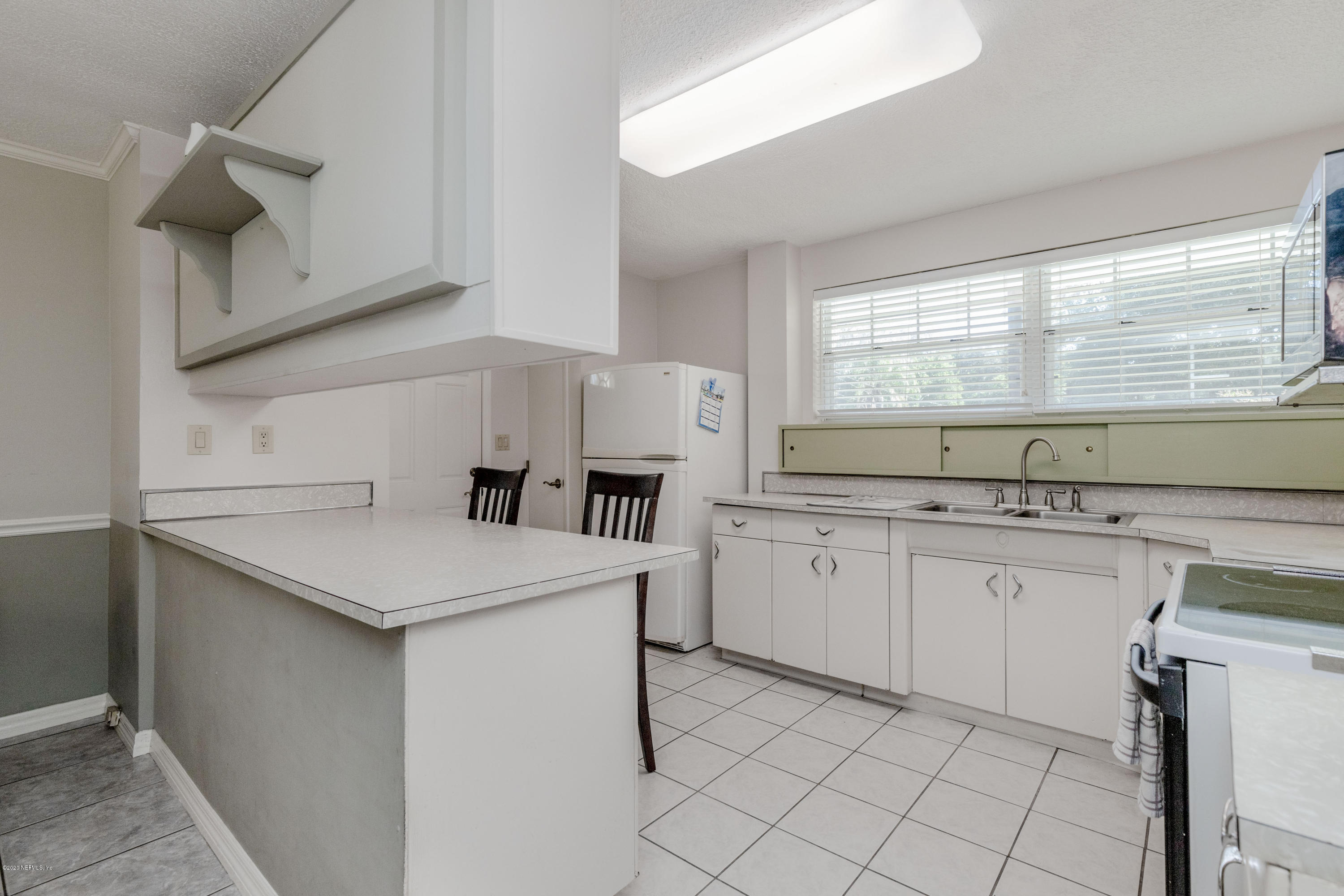 3118 Kline Road Jacksonville, FL 32246 - Photo 7 of 39 a kitchen with sink cabinets and window