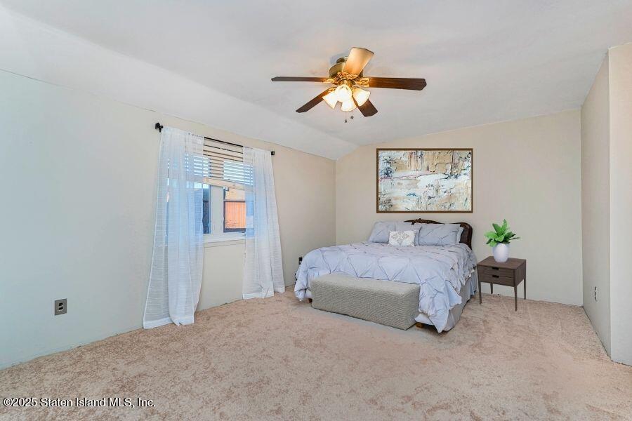 21 Alan Loop Staten Island, NY 10304 - Photo 15 of 27 a spacious bedroom with a bed and a chandelier
