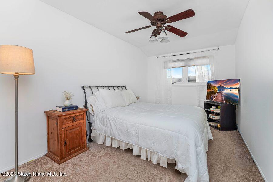21 Alan Loop Staten Island, NY 10304 - Photo 17 of 27 a bedroom with a bed and a chandelier