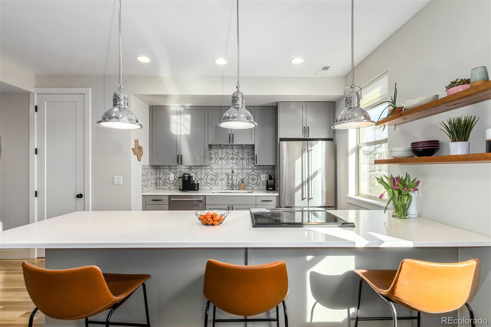 a kitchen with stainless steel appliances kitchen island granite countertop a dining table chairs and white cabinets