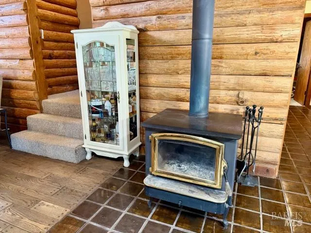 a living room with furniture a flat screen tv and floor to ceiling window