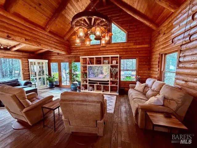 a living room with furniture a large window and wooden floor