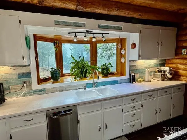 a kitchen with stainless steel appliances sink and large window