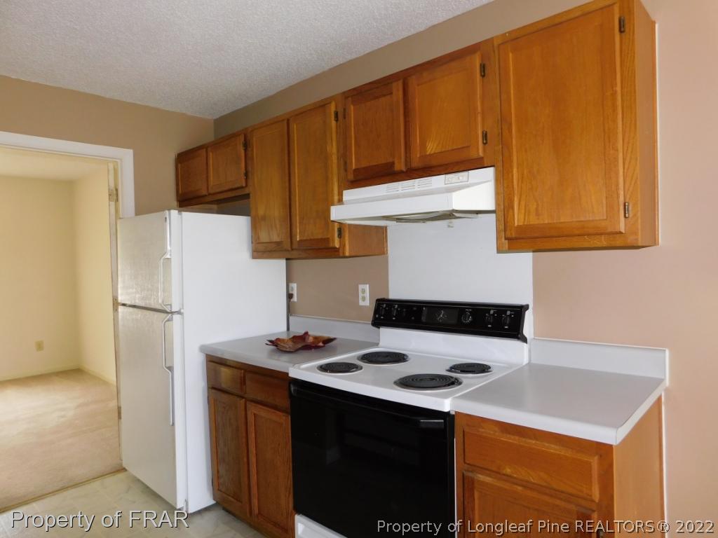 541 Camden Road Raeford, NC 28376 - Photo 13 of 24 a kitchen with stainless steel appliances a stove a refrigerator a sink and white cabinets