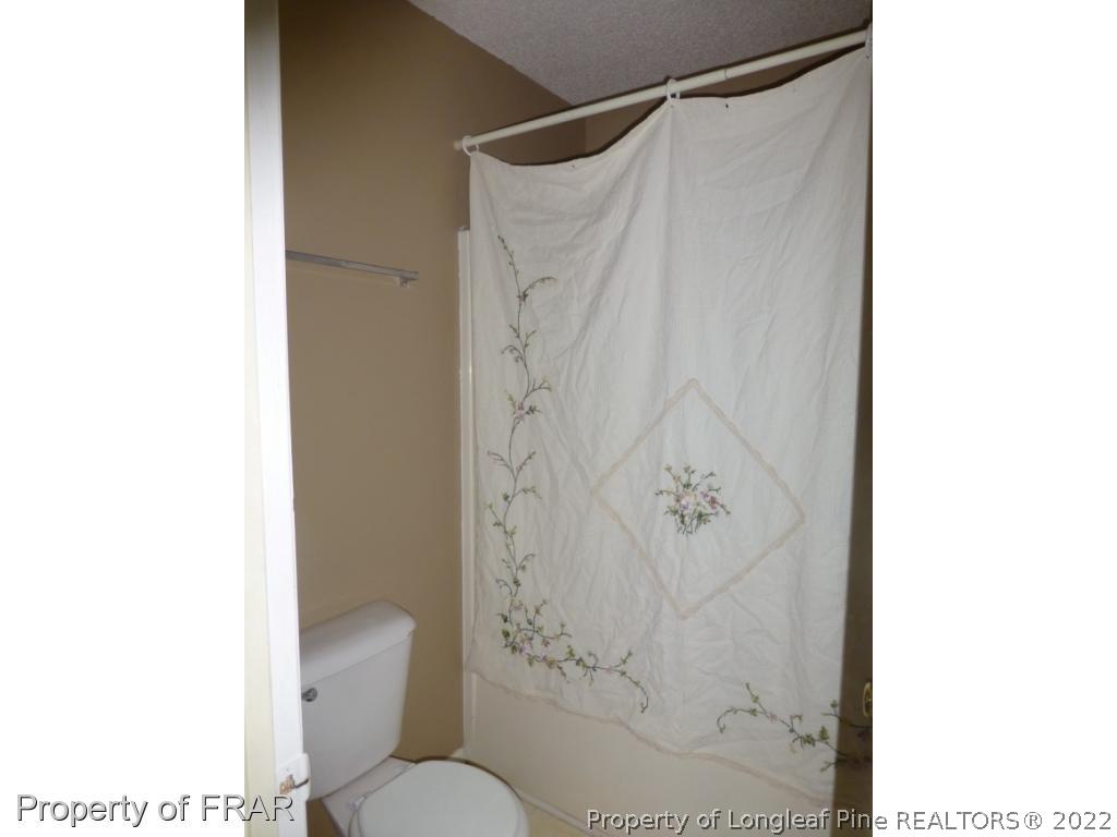 541 Camden Road Raeford, NC 28376 - Photo 17 of 24 a bathroom with a toilet and shower curtain