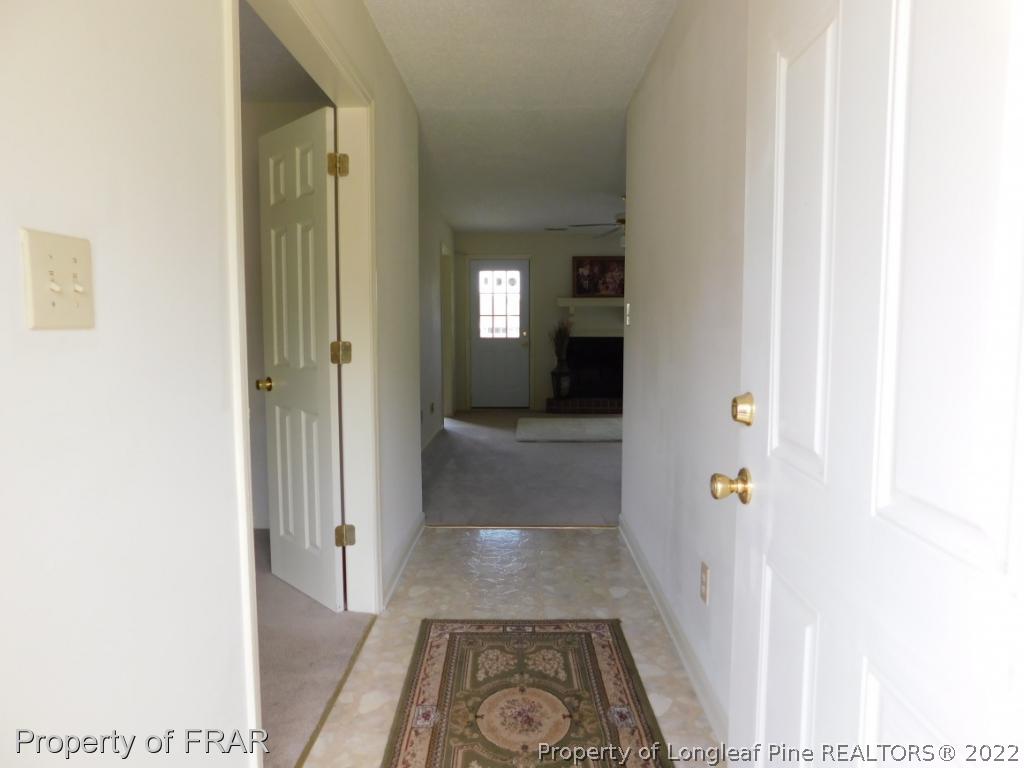 541 Camden Road Raeford, NC 28376 - Photo 3 of 24 a view of a hallway with wooden floor and a bathroom