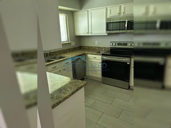 a kitchen with stainless steel appliances granite countertop a sink and a stove