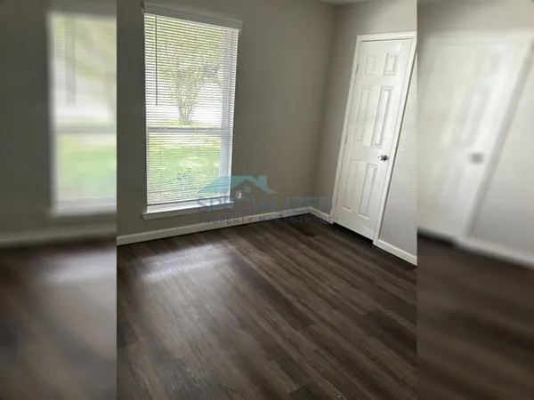 a view of a refrigerator in kitchen and an empty room