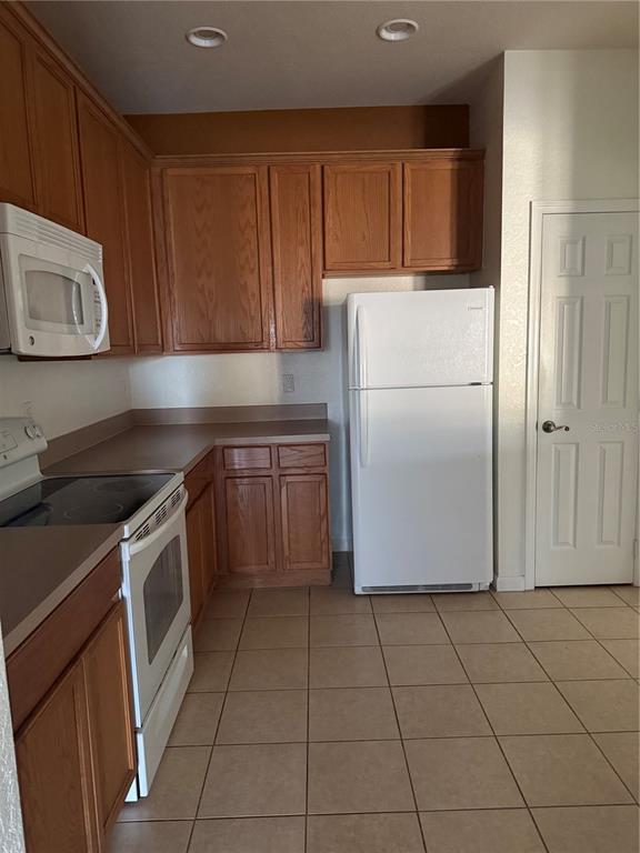 3051 Greystone Loop, Unit 304 Kissimmee, FL 34741 - Photo 11 of 32 a kitchen with a cabinets washer and dryer