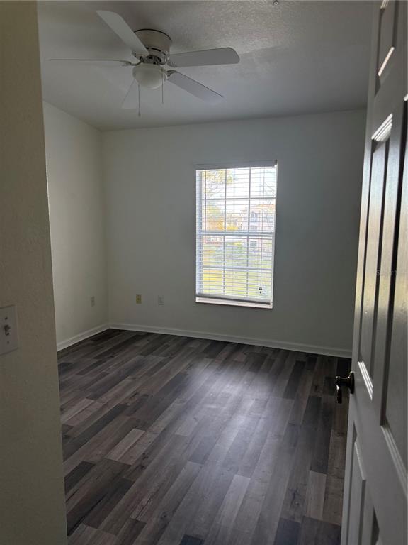 3051 Greystone Loop, Unit 304 Kissimmee, FL 34741 - Photo 22 of 32 an empty room with wooden floor fan and windows