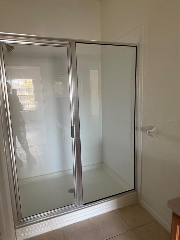3051 Greystone Loop, Unit 304 Kissimmee, FL 34741 - Photo 24 of 32 a bathroom with a glass shower door