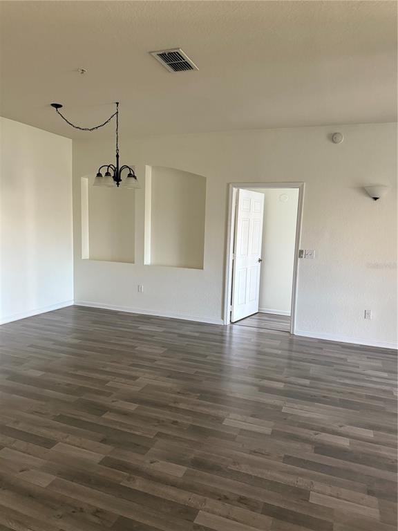 3051 Greystone Loop, Unit 304 Kissimmee, FL 34741 - Photo 6 of 32 a view of an empty room with wooden floor and a ceiling fan